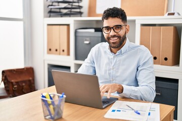 Fototapeta premium Young hispanic man business worker using laptop working at office