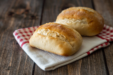 Two tender breads on a napkin and wooden background.