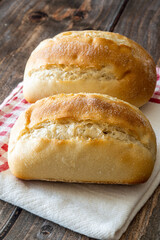 Two tender breads on a napkin and wooden background.