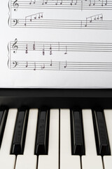 Musical keyboard and handwritten sheet music in a verticall orientation