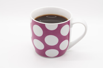 Pink coffee cup with white circles isolated on a white background
