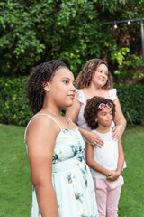Naklejka premium teenage girl standing in the park with her family in the background.