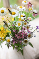Bouquet of wild flowers in a vase on a wooden window sill. Still life on the window of an old country house, summer cottage.selective focus