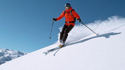 Fototapeta na wymiar Free ride skier running down the hill.