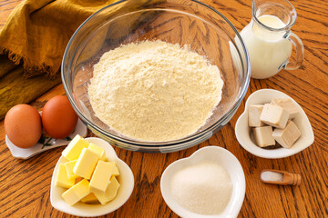 Baking Cooking Ingredients Flour Eggs Butter sugar, salt, milk, pressed yeast And Kitchen Textile On wooden table Background. Side View Copy Space. Cookies Or Cake bread Recipe Mockup