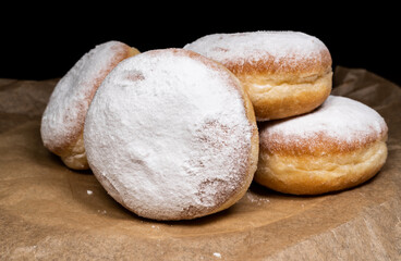 Polish pączki deep-fried doughnuts. Celebrating Fat Thursday (Tłusty czwartek) feast, traditional day in Poland. Pączek food, powdered sugar topped and filled with rose hip jam.