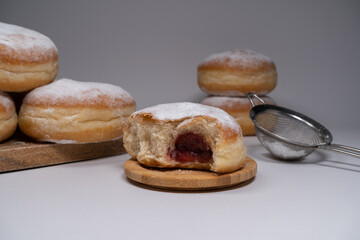 Pączki deep-fried Polish doughnuts. Celebrating Fat Thursday, Tłusty czwartek feast, traditional day in Poland. Pączek food, powdered sugar topped and filled with rose hip jam.