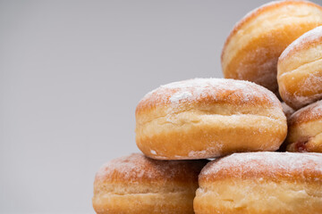 Polish pączki deep-fried doughnuts with copy space. Celebrating Fat Thursday (Tłusty czwartek) feast, traditional day in Poland. Pączek food, powdered sugar topped and filled with rose hip jam.
