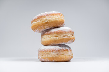 Polish pączki deep-fried doughnuts. Celebrating Fat Thursday, Tłusty czwartek feast, traditional day in Poland. Pączek food, powdered sugar topped and filled with rose hip jam.