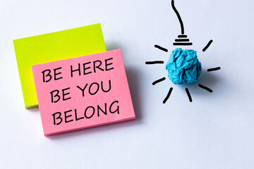 A symbol of belonging. words, be here, be you belong, written on colored cards, light bulb icon,...