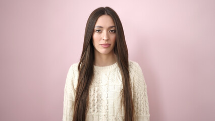 Young beautiful hispanic woman standing with relaxed expression over isolated pink background