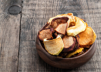Dried fruits in wooden bowl on wooden table