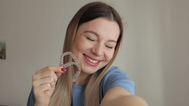 Woman Wearing Orthodontic Plastic Invisalign Brace. Mobile Orthodontic Appliance For Dental Correction. Tooth Whitening Systems. Woman Holding Invisalign Braces, Dental Healthcare And Orthodontic
