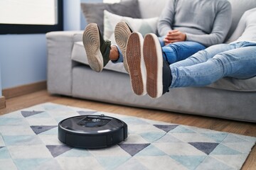 Two men cleaning floor using cleaner vacuum robot at home