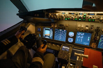 A man is studying to be a pilot in a flight simulator. Close-up of male hands navigating an...