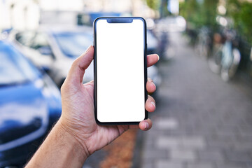 Man holding smartphone showing white blank screen at street
