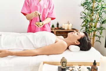 Obraz na płótnie Canvas Middle age hispanic woman having aromatic treatment at beauty center