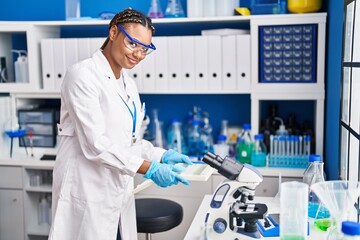 African american woman scientist holding samples at laboratory