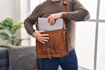 Young caucasian man business worker holding laptop of briefcase at office