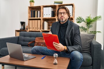 Handsome middle age man working at consultation office looking at the camera blowing a kiss on air being lovely and sexy. love expression.