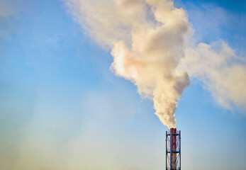Smoke exhausting from chimney. Huge smoke from the pipe. Red-white chimney of factory....