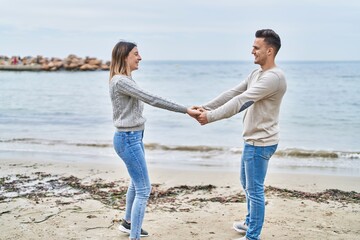 Man and woman couple smiling confident dancing at seaside