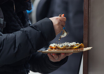 A customer at the Naplavka winter farmers market in Prague seasoning her toast.