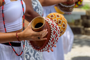 Woman playing a type of rattle called xereque of African origin used in the streets of Brazil...