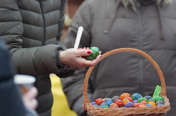 Customers at the Naplavka farmers market in Prague buy painted eggs, a traditional Easter...