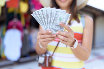 Young asian woman tourist smiling confident counting dollars at street market