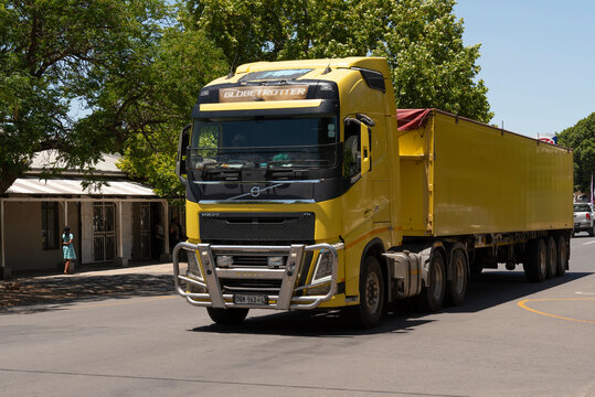 Western Cape, South Africa. 2023.  Yellow painted truck and trailer passing through the Western Cape area.