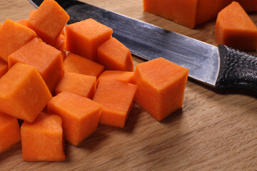 knife and pieces of pumpkin on a cutting board. Cooking baked pumpkin or baby puree