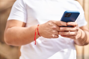 Young chinese man using smartphone at street