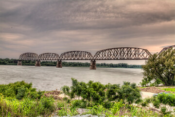Obraz premium View of the Metropolis BNSF railroad bridge over the Ohio River. Dramatic clouds over the river. 