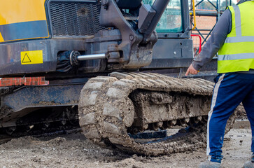 Excavator with broken track in need of repair