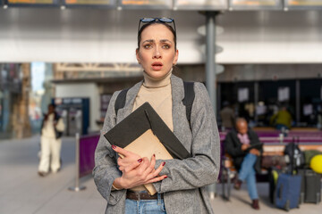 Traveler with a backpack waiting for a train at the train station. Woman missed the train. Travel concept.