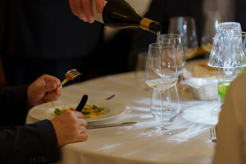 The sommelier serves wine