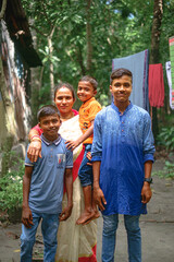 family in the park, portrait of a family, middle aged mother with her three young sons...