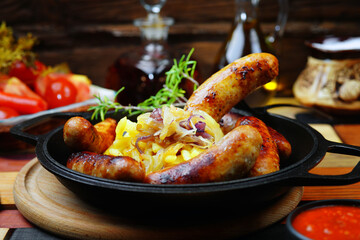 Grilled homemade sausages in a cast iron pan with cabbage and onions. Beautiful background.
