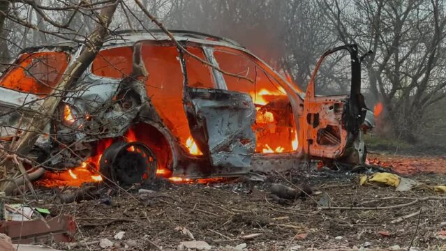 Burning car on the side of the road. Insured event, misfortune, accident, incident, loss