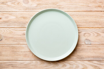 Top view of empty blue plate on wooden background. Empty space for your design