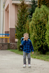 Obraz premium Schoolboy looking through a magnifying glass, with a surprised expression, squinting his eyes
