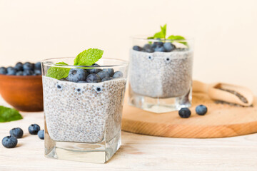 Obraz na płótnie Canvas Healthy breakfast or morning with chia seeds vanilla pudding and blueberry berries on table background, vegetarian food, diet and health concept. Chia pudding with coconut milk and blueberry