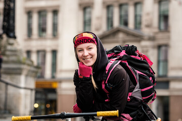 Portrait of smiling bike courier woman looking at camera in a friendly way.