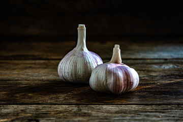 Two heads of garlic on a kitchen wooden table.