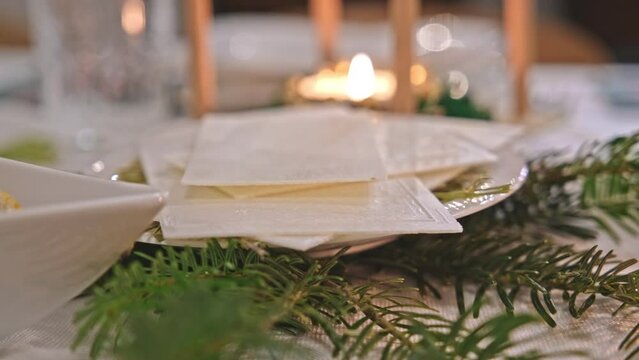 Traditional Polish Christmas Eve Dinner Table with White Christmas Wafer Laying on Hay