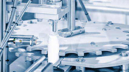 pharmaceutical industry, medicine pills are filling in the  plastic bottle on production line machine conveyor at the medical factory. selective focus.