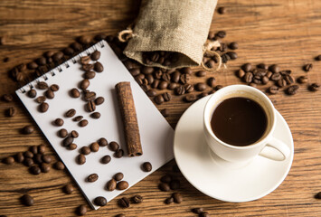 Cup of coffee, notebook and coffee beans
