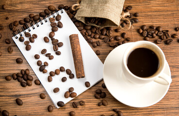 Cup of coffee, notebook and coffee beans