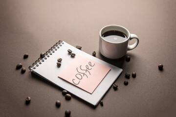 The inscription coffee and a notepad with a cup of coffee